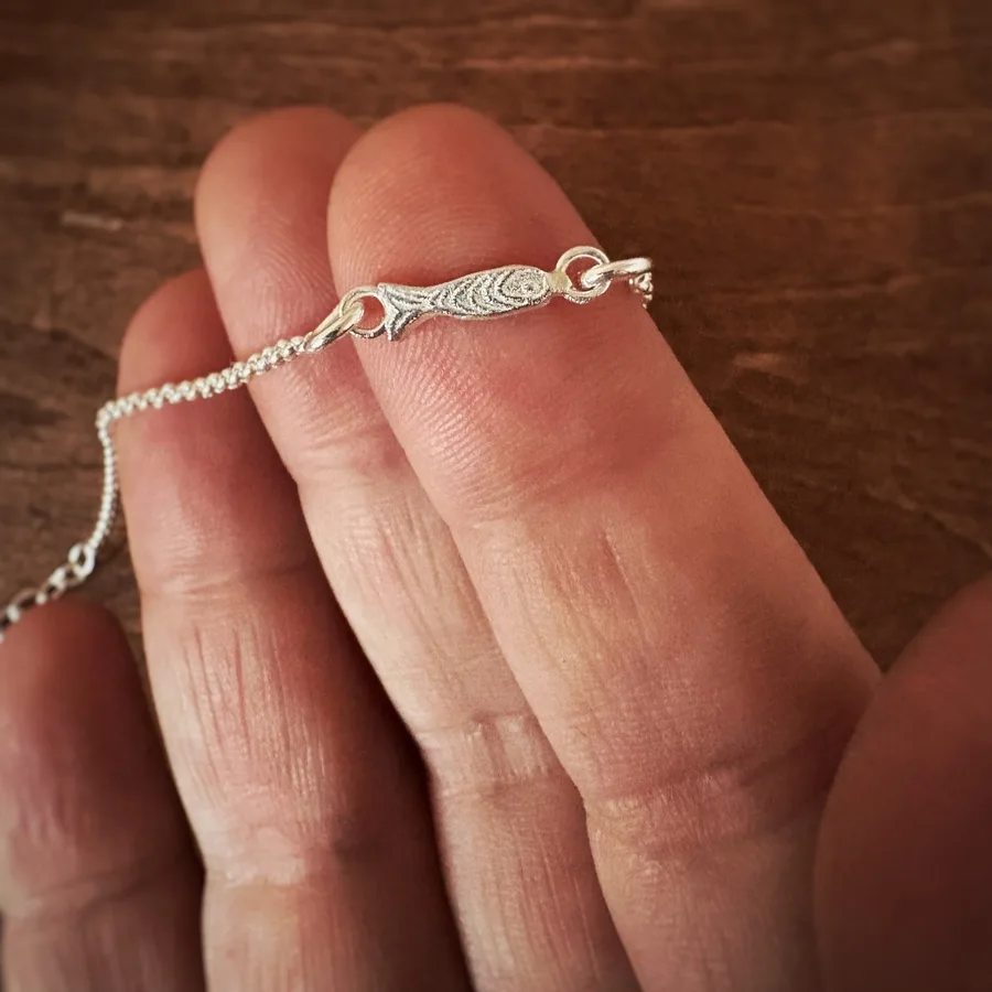 This delicate tiny fish bracelet features a tiny fish charm crafted from solid 925 sterling silver, strung on a fine sterling silver chain. The design is inspired by the calm and beauty of the Mediterranean Sea. Handmade in a small village near Barcelona, this bracelet makes a perfect minimalist gift for ocean lovers.