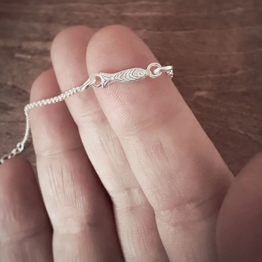This delicate tiny fish bracelet with a tiny fish charm crafted from solid 925 sterling silver, strung on a fine sterling silver chain. The design is inspired by the calm and beauty of the Mediterranean Sea. Handmade in a small village near Barcelona, this bracelet makes a perfect minimalist gift for ocean lovers.