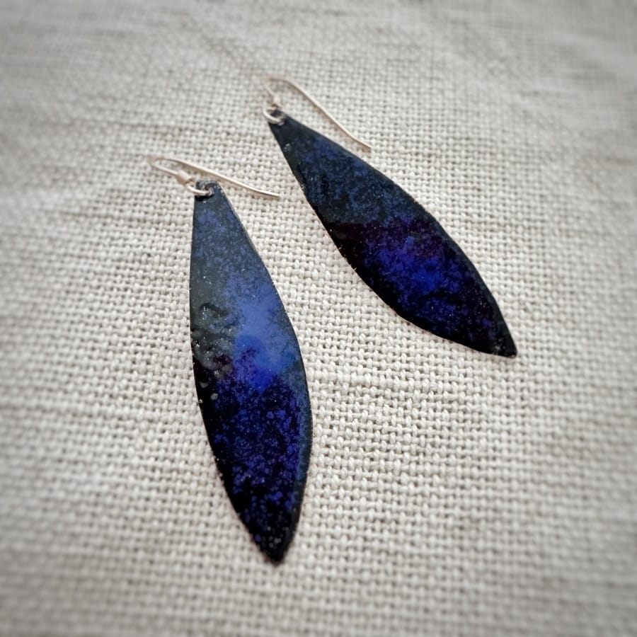 Handcrafted blue leaf earrings made with copper, low-temperature enamels and sterling silver hooks. A contemporary design featuring deep blue and black tones with elegant organic lines.